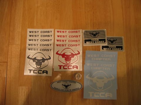 2002 Ford Taurus - Various decals for the Taurus Car Club of America are laid out on a wooden surface.