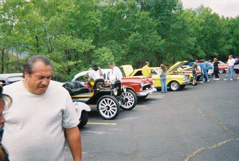 1972 Ford Ranchero - A variety of classic cars are displayed at an outdoor car show, with attendees mingling around them.