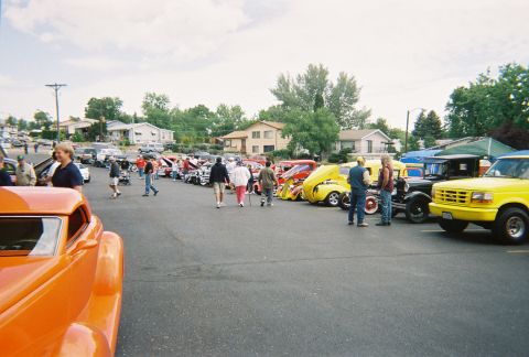 1972 Ford Ranchero - People attend an outdoor car show a variety of vehicles parked in rows under a cloudy sky.