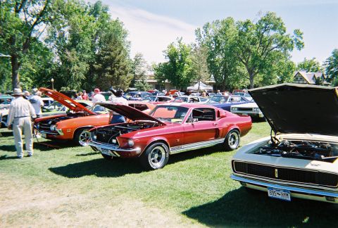 1972 Ford Ranchero - A red 1967 Ford Mustang Fastback is displayed with its hood open at a car show, alongside other vehicles.