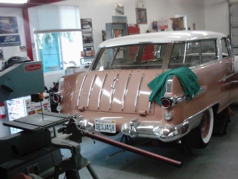 1978 Ford Bronco - Rear view of a vintage station wagon in a garage setting, showing its distinctive tailgate and chrome bumper.