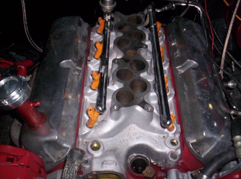 Engine intake manifold with orange fuel injectors and chrome fuel rails