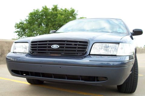 1998 Ford Crown Victoria - Front view of a dark blue 2003 Ford Crown Victoria with a black grille and clear headlights.