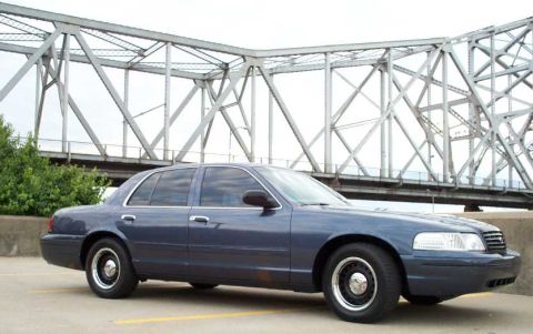 1998 Ford Crown Victoria - Dark blue 1998 Ford Crown Victoria parked near a large metal bridge structure.
