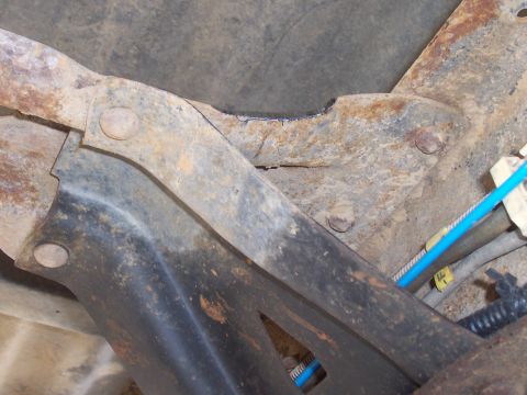 1994 Ford F-150 - Close-up view of vehicle undercarriage parts, showing rust and a blue hose.