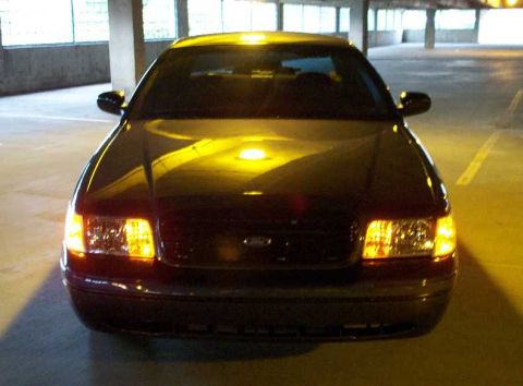 1998 Ford Crown Victoria - This 1998 Ford Crown Victoria is shown from the front in a parking garage, with its headlights illuminated.