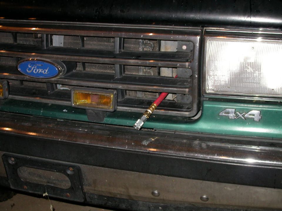 Front grille of Ford 4x4 truck with blue oval emblem and amber turn signal