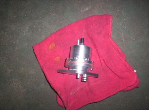 1989 Ford Bronco II - A metal fuel pump rests on a red cloth on a dark surface.
