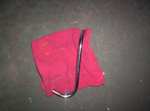 1989 Ford Bronco II - A metal rod lies on a stained red cloth against a dark background.