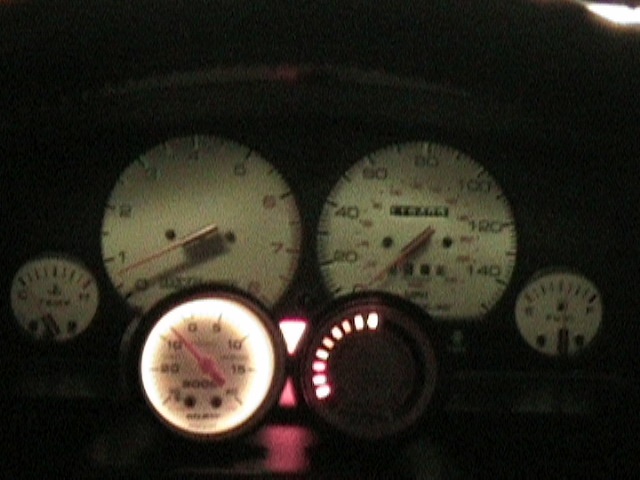 Car dashboard with speedometer, tachometer, and other gauges lit up