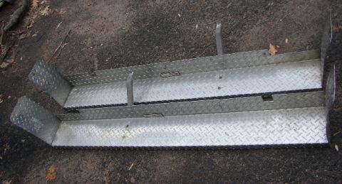 1995 Ford Bronco - Two diamond plate running boards are shown lying on the ground.