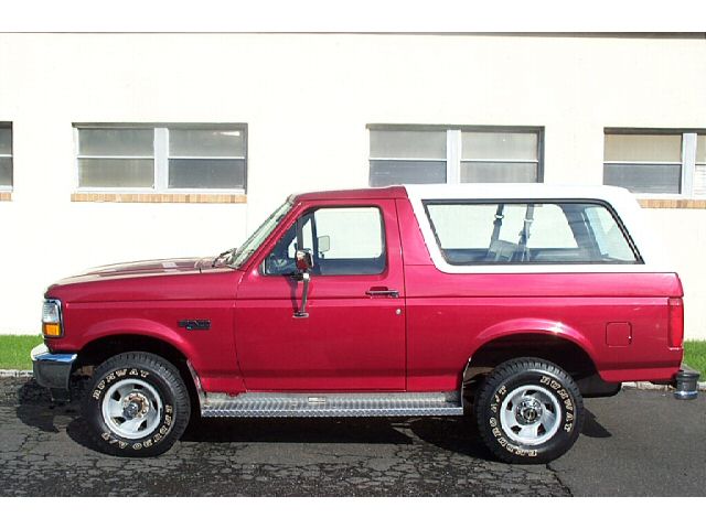 Side view of red 1995 Ford Bronco with white top