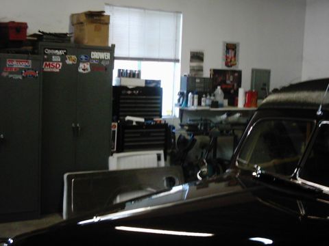 1978 Ford Bronco - A black vehicle's interior is visible, parked in a garage with tools and supplies on shelves.