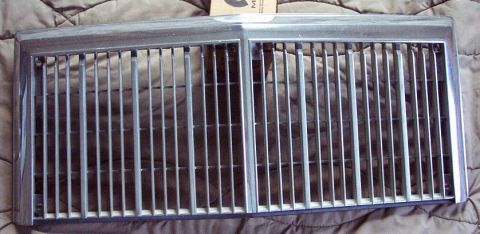 1985 Ford LTD Crown Victoria - A detached chrome grille with a segmented design, likely a replacement part for a vehicle.