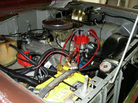 1995 Ford Bronco - The engine bay of a vehicle is shown, a V8 engine with various components like the carburetor and battery.