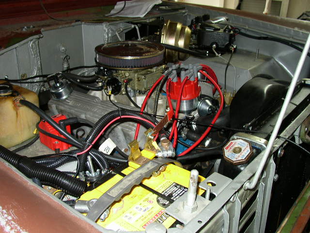 engine bay with V8 engine, carburetor, distributor, battery, and brake booster