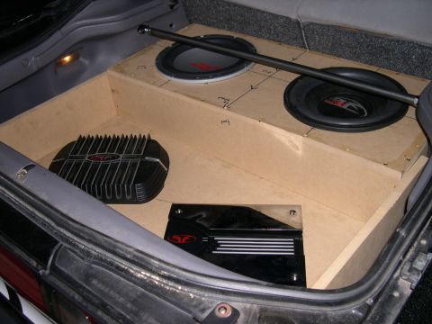 1997 Ford Probe - Raw MDF subwoofer enclosure and amp rack mocked up in a hatch area, holding two Alpine Type-R subwoofers up top with pencil layout marks st…