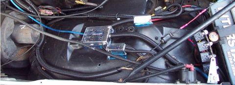 1985 Ford Crown Victoria LTD - Close-up view of the complex wiring harness, fuse box, and relay system within a vehicle's engine bay.
