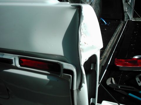 1978 Ford Bronco - Close-up of a damaged rear quarter panel on a 1978 Ford Bronco, showing bodywork issues.