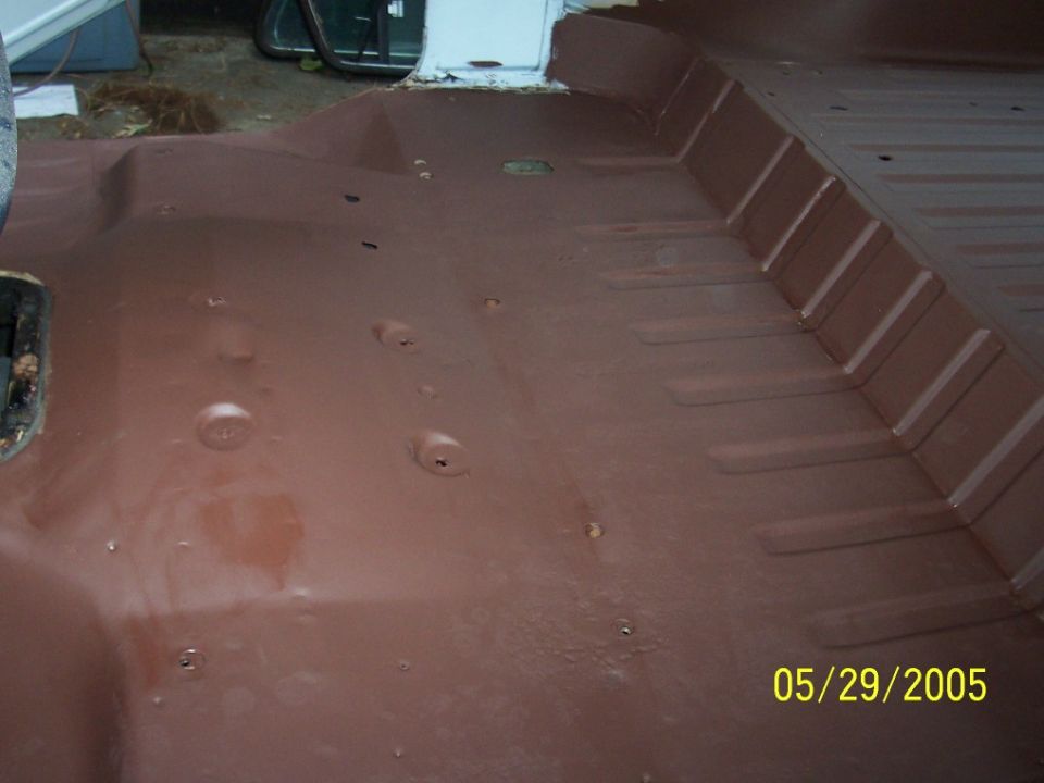 Vehicle floor with brown coating and visible mounting points