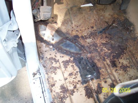 1979 Ford Bronco - The interior floor of a vehicle shows significant rust and repair work, with pedals visible.