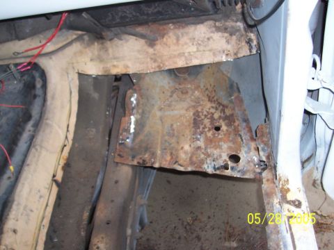 1979 Ford Bronco - Close-up of severely rusted vehicle floor pan and frame structure.