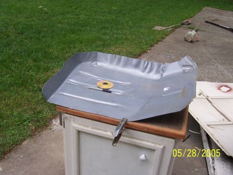 1979 Ford Bronco - A gray car floor pan, possibly for a 1979 Ford Bronco, is shown resting on a cabinet outdoors.