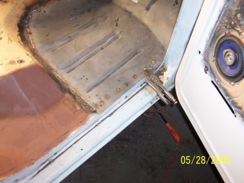 1979 Ford Bronco - Metal floor pan repair in progress, showing welding and a clamp holding metal in place.