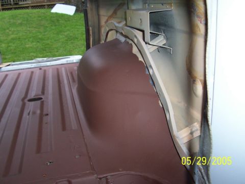 1979 Ford Bronco - The interior floor and wheel well of a vehicle are shown coated in brown primer.