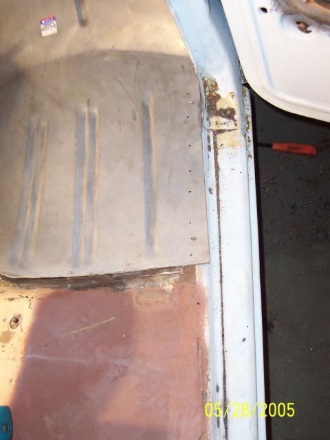 1979 Ford Bronco - The interior floor pan of a vehicle shows signs of wear and repair, with visible metal seams and some rust.