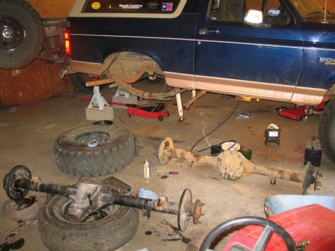 1995 Ford Bronco - Rear axle removed from a 1995 Ford Bronco during a swap in a garage setting.