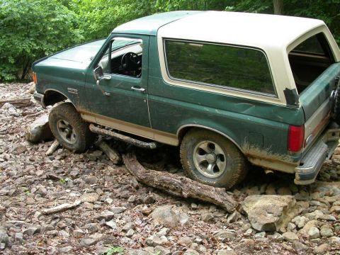 1990 Ford Bronco - This 1990 Ford Bronco navigates a rocky path with a fallen tree obstructing its way.