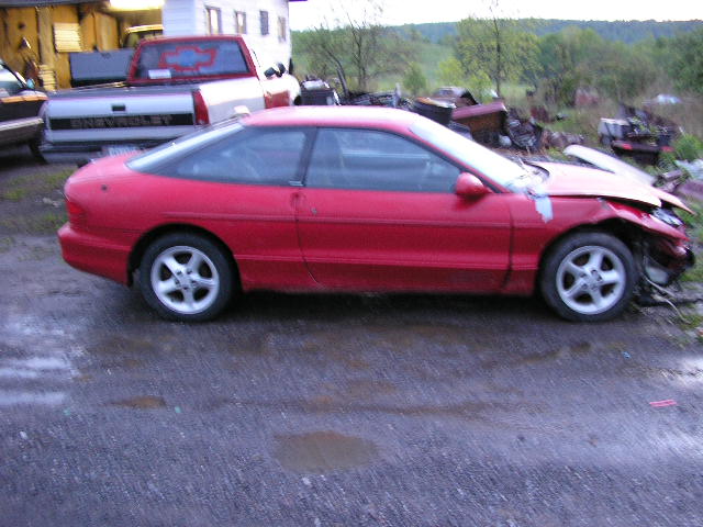 red sports coupe with damaged front end, parked next to a Chevrolet pickup truck
