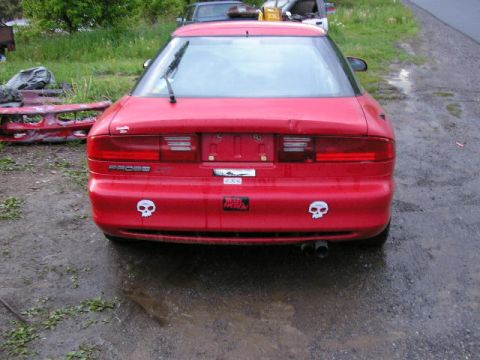 1994 Ford Probe - Rear view of a red 1994 Ford Probe GT with skull stickers and dual exhaust pipes.