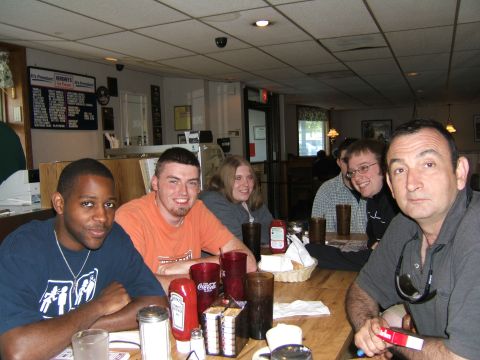 1998 Ford Taurus - A group of friends enjoy a meal together at a diner, with condiments and drinks on the table.