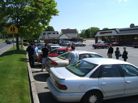 1998 Ford Taurus - Silver sedan parked in a lot with other vehicles and people.