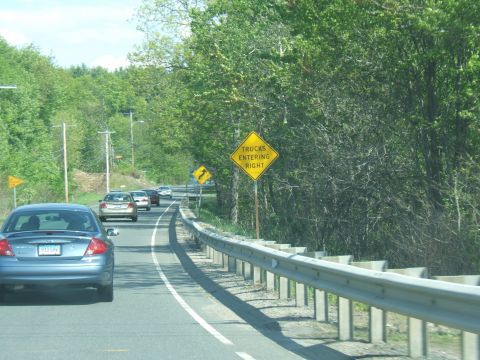 1998 Ford Taurus - Highway scene with multiple cars and a 'trucks entering right' traffic sign.