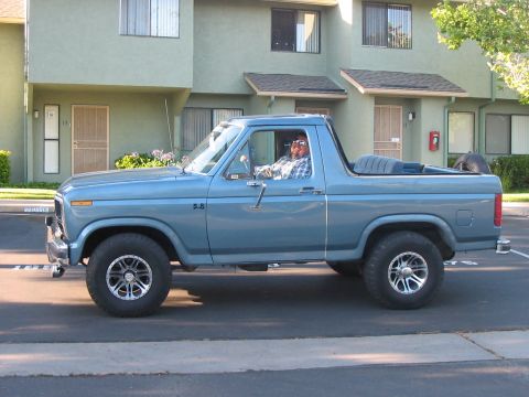 1986 Ford Bronco - Side view of a blue 1986 Ford Bronco, a "5.8" badge on the fender.