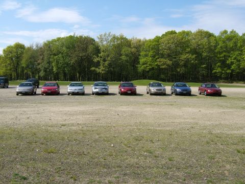 1998 Ford Taurus - A group of sedans, including a 1998 Ford Taurus, are parked in an outdoor lot on a sunny day.