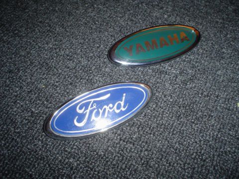 1995 Ford Taurus - Two automotive emblems, one for Ford and another for Yamaha, are displayed on a textured surface.