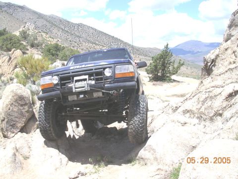 1994 Ford Bronco - Blue 1994 Ford Bronco tackling rough terrain off-road.