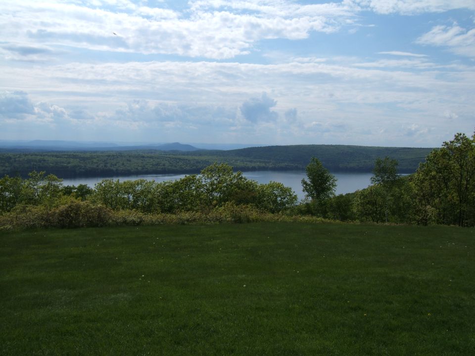 view of lake and trees under cloudy sky