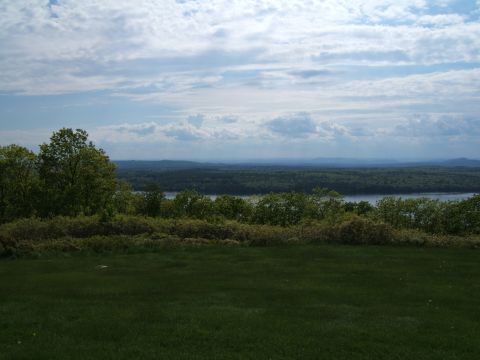 1998 Ford Taurus - A wide view of a landscape a lake or river surrounded by trees, under a partly cloudy sky.