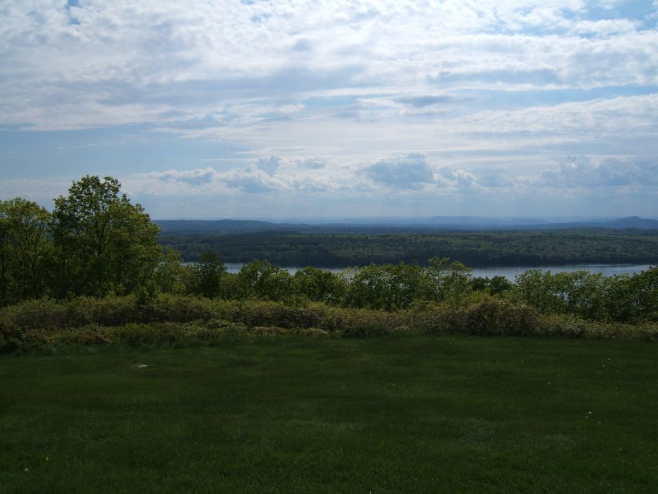 Scenic landscape with a body of water and trees under a cloudy sky