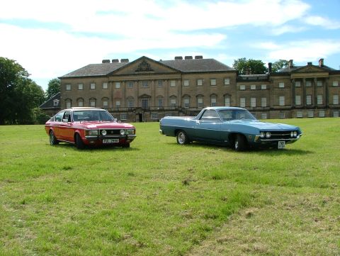 1970 Ford Ranchero - A blue 1970 Ford Ranchero and a red coupe are parked on a grassy lawn in front of a stately manor house.