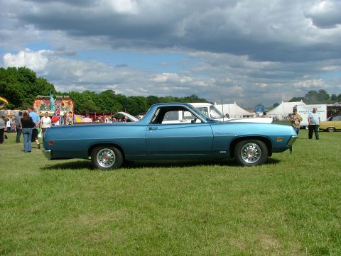 1970 Ford Ranchero - Side view of a blue 1970 Ford Ranchero at an outdoor gathering with tents and people in the background.