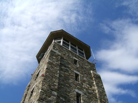 1998 Ford Taurus - A stone tower with multiple windows and a hexagonal roof stands against a bright blue sky with scattered clouds.
