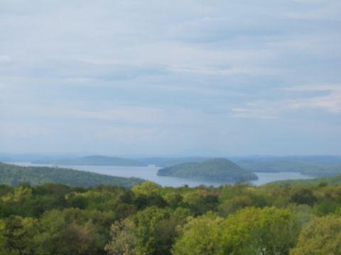 1998 Ford Taurus - A wide shot captures a lake among rolling, tree-covered hills under a hazy sky.