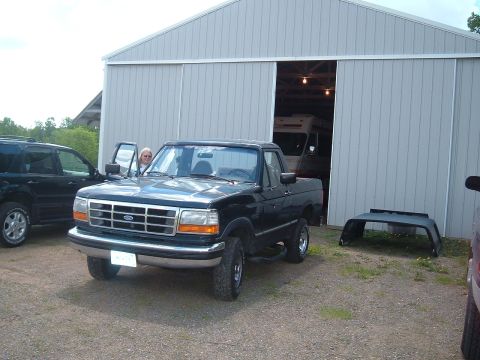 1994 Ford Bronco - A black 1994 Ford Bronco is parked in front of a garage with a woman in the driver's seat.