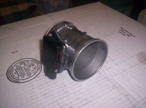 1989 Ford Bronco II - A mass air flow sensor is shown resting on a cardboard box with some markings.